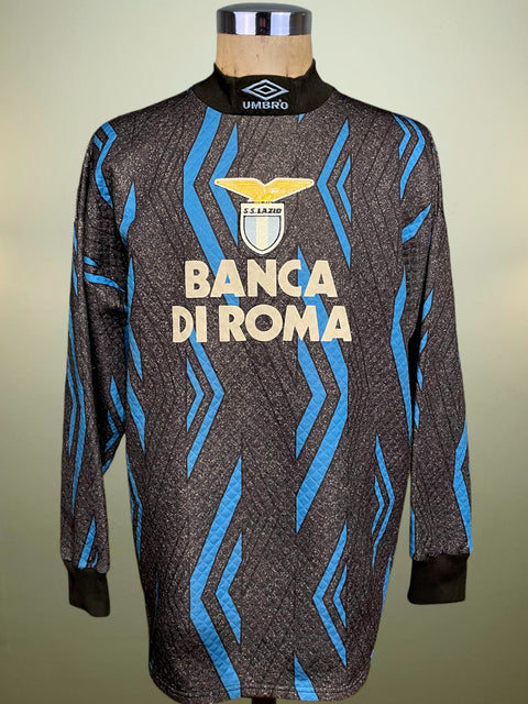 Soccer jersey with blue and black patterns on a mannequin against a neutral background