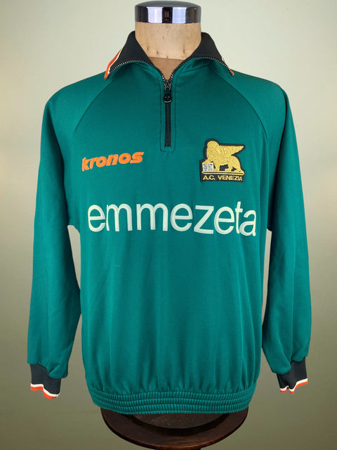 Green Venezia Training jacket with Kronos Logo on a mannequin against a beige background