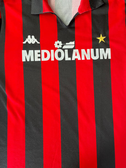 Close-up of a 1987 AC Milan jersey with red and black stripes and 'Mediolanum' text.