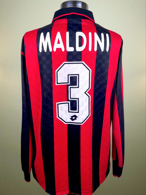 Red and black striped AC Milan 1995-96 jersey with 'Maldini' and number '3' on a mannequin against a neutral background