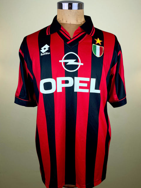 Red and black striped AC Milan 1996-97 Lotto jersey with Opel logo on a mannequin against a neutral background
