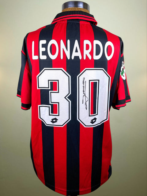 Red and black striped AC Milan 1997-98 jersey with 'Leonardo' and number '30' on a beige background