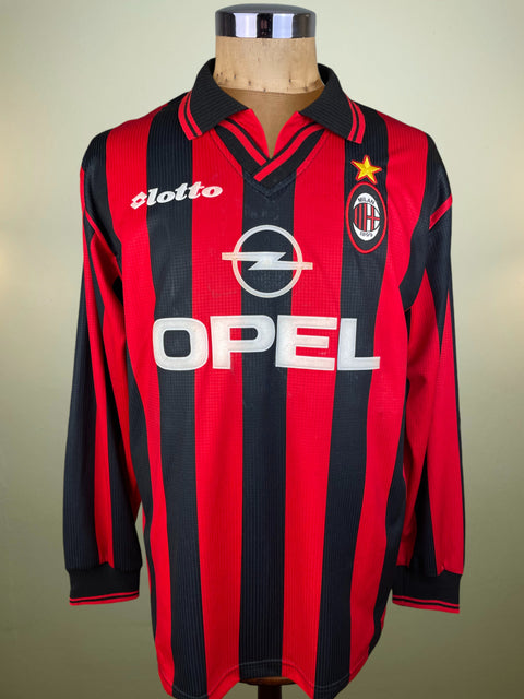 Red and black striped AC Milan 1997 jersey with Opel and Lotto logos on a mannequin against a beige background