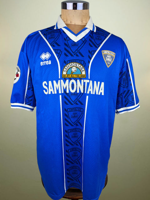 Blue Empoli 97-98 jersey with branding on a mannequin against a beige background