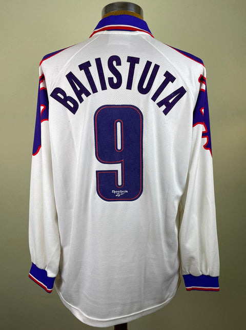 A white Fiorentina 1995-96 jersey with red and blue accents, featuring the name 'BATISTUTA' and the number '9' on the back.