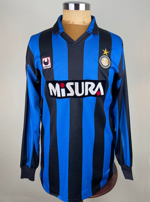 Lothar Matthaus's long-sleeved Inter Milan soccer jersey fron the 1990-91 season with blue and black stripes, featuring a logo on the chest and the name 'MISURA' in bold lettering.