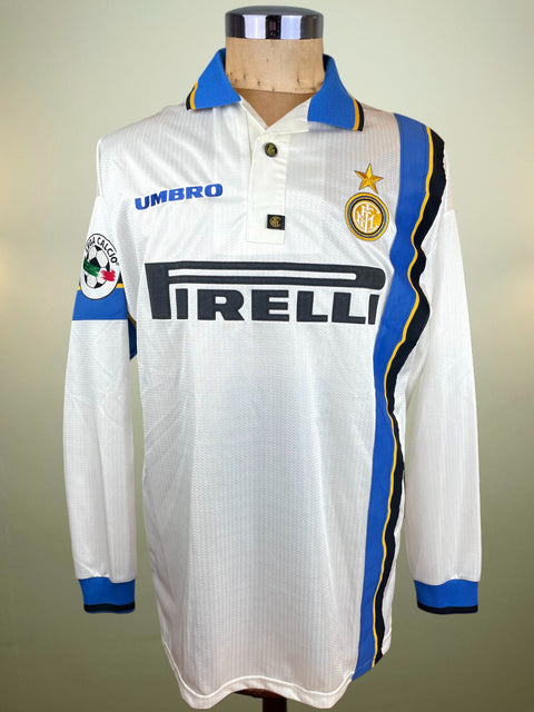 White Inter Milan away jersey with blue and yellow accents on a mannequin against a neutral background
