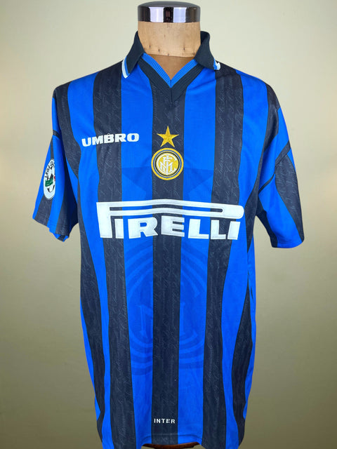 Blue and black striped Inter Milan 1997-98 jersey with Umbro and Pirelli logos on a mannequin against a beige background