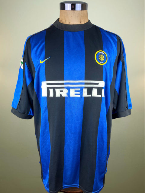 Blue and black Inter Milan 1999-00 jersey with Nike and Pirelli logos on a mannequin against a beige background