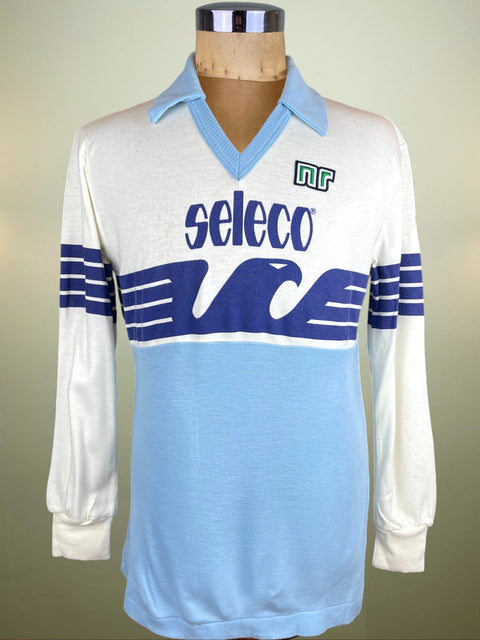 White and blue Lazio 1982 Home jersey with 'seleco' sponsor, and made by Ennerre on a mannequin against a beige background