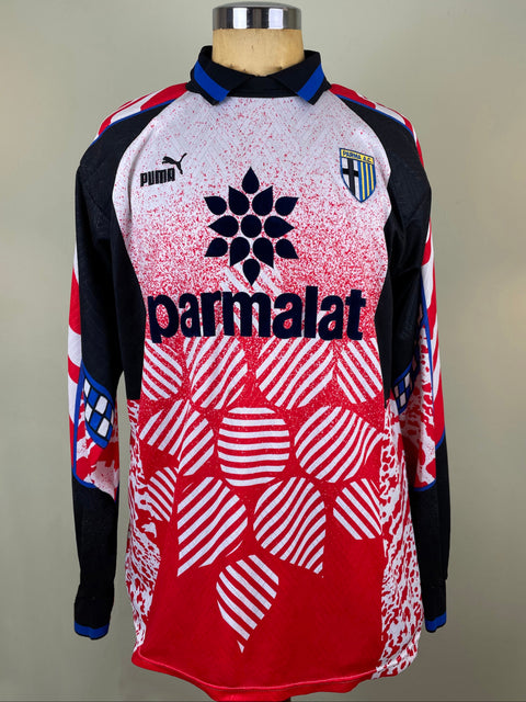 A vintage Puma soccer jersey displayed on a mannequin torso. The long-sleeve jersey features a red, white, and black gradient design with a geometric pattern on the lower half, a black Puma logo on the right chest, and a black 'parmalat' sponsor logo across the center.