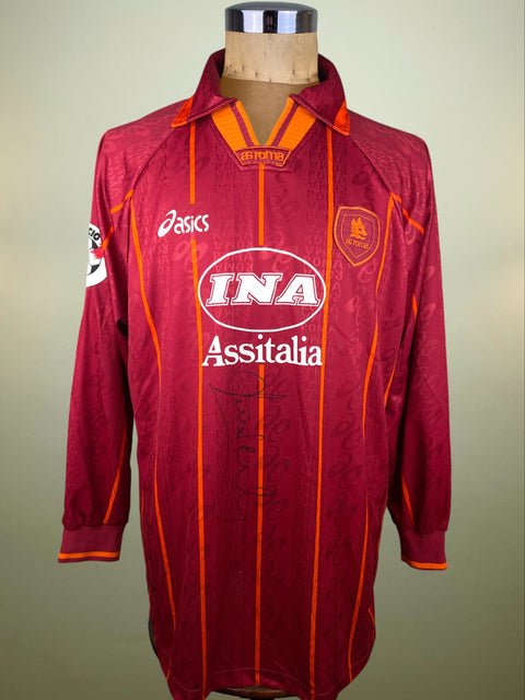 Maroon AS Roma 1996-97 home jersey with orange accents and INA Assitalia sponsor, with Daniel Fonseca's autograph on the front in black marker, on a mannequin against a neutral background