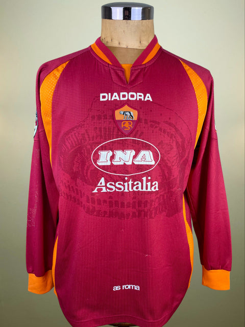 Maroon sports jersey with orange accents on a mannequin against a beige background