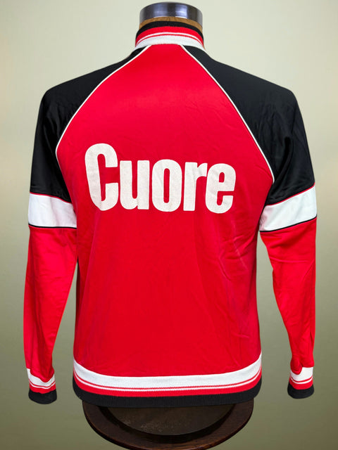 A red and black long-sleeve jacket displayed on a mannequin from the back, featuring the word 'Cuore' in large white letters across the center.