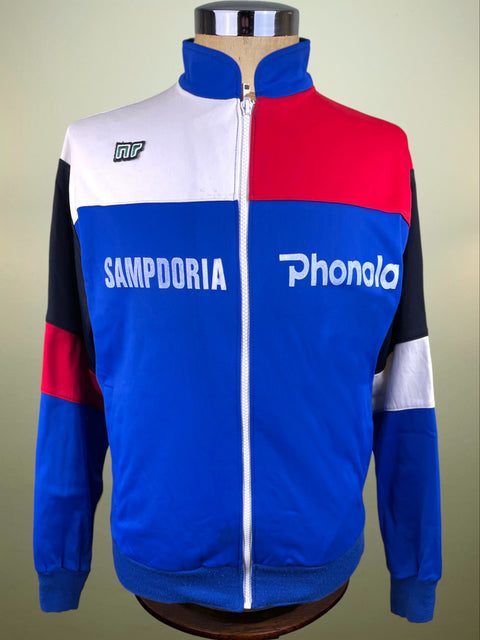A vintage colorblock track jacket displayed on a mannequin torso. The jacket features a colorblock design of blue, red, white, and black, with 'SAMPDORIA' and 'Phonola' printed in white across the chest.