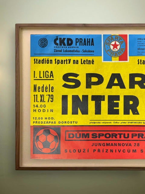 Framed vintage soccer match poster with colorful text and logos on a light background