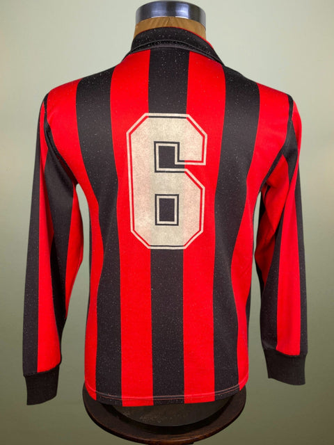 A red and black striped 1988 AC Milan jersey with the number 6 in white flock numbering on the back, displayed on a mannequin.