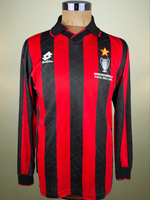 A long-sleeve red and black striped soccer jersey displayed on a mannequin torso. The jersey features vertical red and black stripes, a black collar, the white Lotto logo on the right chest, and the Tokyo 1998 World Cup emblem on the left chest with a gold star.