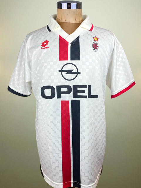 White AC Milan Away jersey from the 1995-96 Season made by Lotto with red and black stripes on a mannequin against a beige background