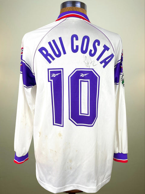 White sports jersey with 'Rui Costa' and number '10' on a mannequin against a neutral background