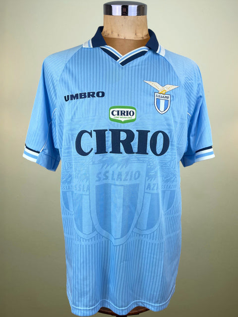 Light blue sports jersey with branding on a mannequin against a beige background