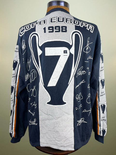 A long-sleeve navy and white soccer jersey displayed on a mannequin, featuring 'COPA EUROPA 1998', a large number 7, and multiple player signatures on the back.