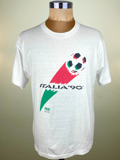 White t-shirt with 'Italia '90' soccer design on a mannequin against a beige background