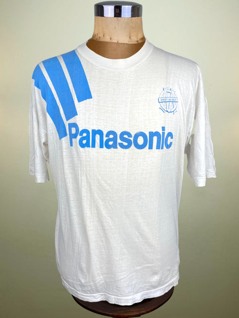 White t-shirt with blue Panasonic logo on a mannequin against a beige background