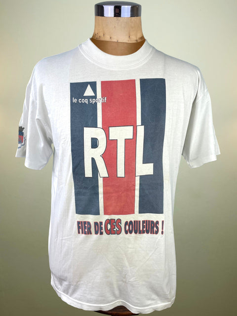 White t-shirt with RTL logo and text on a mannequin against a beige background