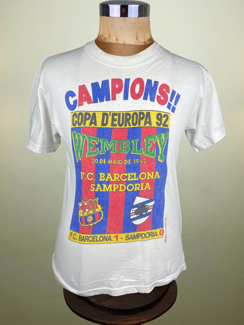 White t-shirt with colorful text and graphics on a mannequin against a beige background