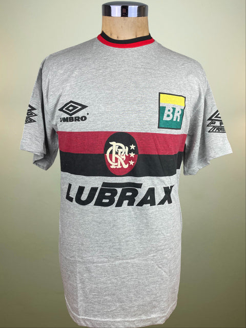 Gray sports jersey with multiple brand logos on a mannequin against a beige background