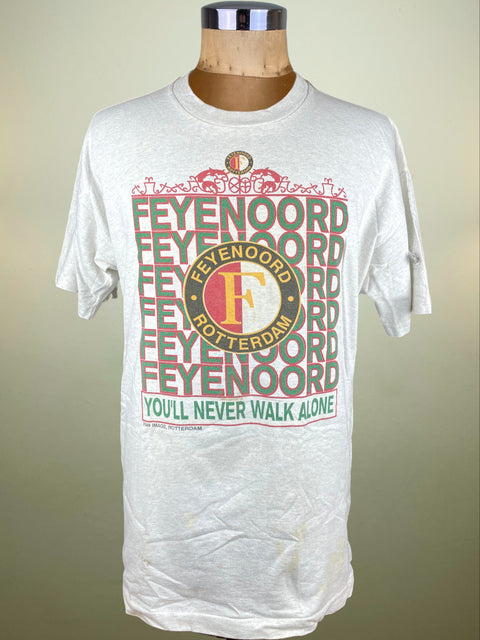 White t-shirt with Feyenoord Rotterdam text and logo on a mannequin against a beige background