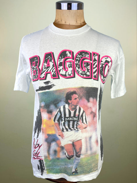 White t-shirt with soccer player graphic and 'BAGGIO' text on a mannequin against a beige background