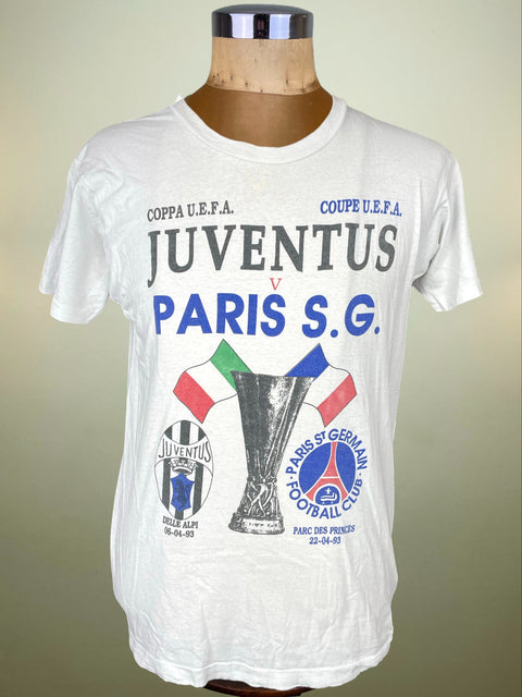 White t-shirt with Juventus and Paris Saint-Germain text and graphics on a mannequin against a beige background