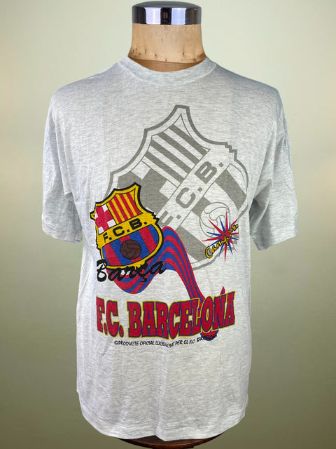 Gray t-shirt with F.C. Barcelona logo on a mannequin against a beige background