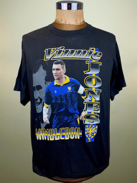 A black graphic t-shirt featuring Vinnie Jones, displayed on a wooden mannequin torso against a plain beige background.