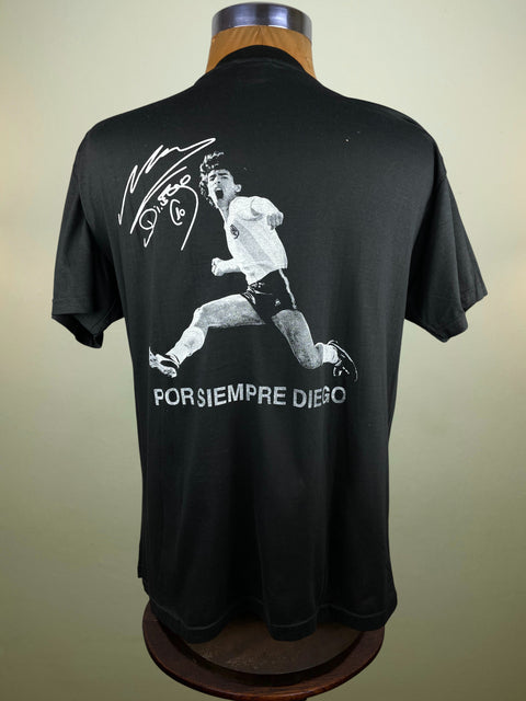 Black t-shirt with a graphic of a Diego Maradona and text saying Por Siempre Diego on a mannequin against a beige background