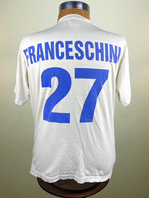 White sports jersey with blue text and number on a mannequin against a beige background
