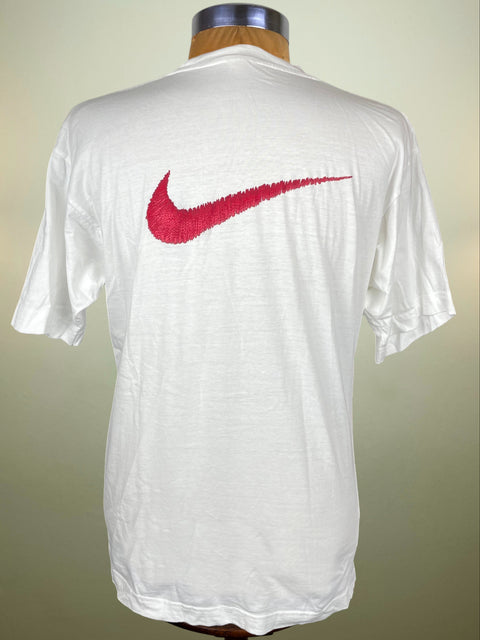 White t-shirt with a red Nike logo on a mannequin against a neutral background