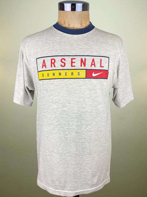 Gray t-shirt with Arsenal branding on a mannequin against a beige background