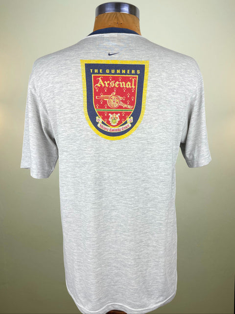 Gray sports jersey with Arsenal logo on a mannequin against a neutral background