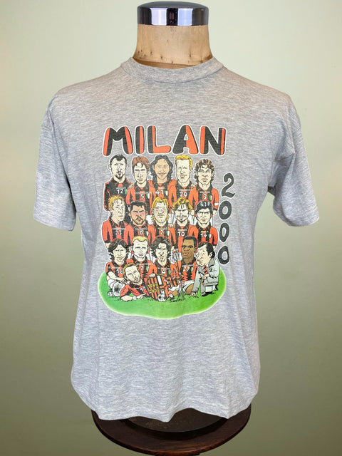 Gray t-shirt with a colorful graphic of people and 'Milan 2000' text on a mannequin against a beige background