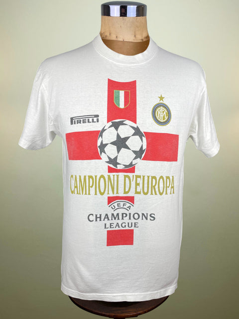 White Inter Milan Champions League t-shirt with red and black design on a mannequin against a gradient background
