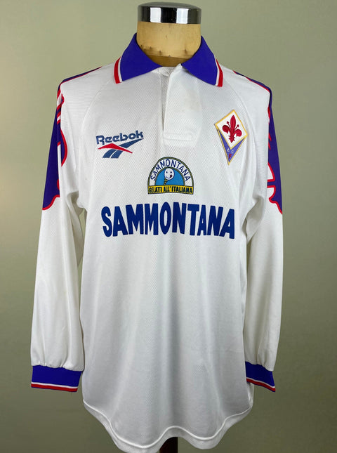 White Fiorentina 1995-96 jersey with blue and red accents on a mannequin against a gray background with the Sammontana Sponsor.