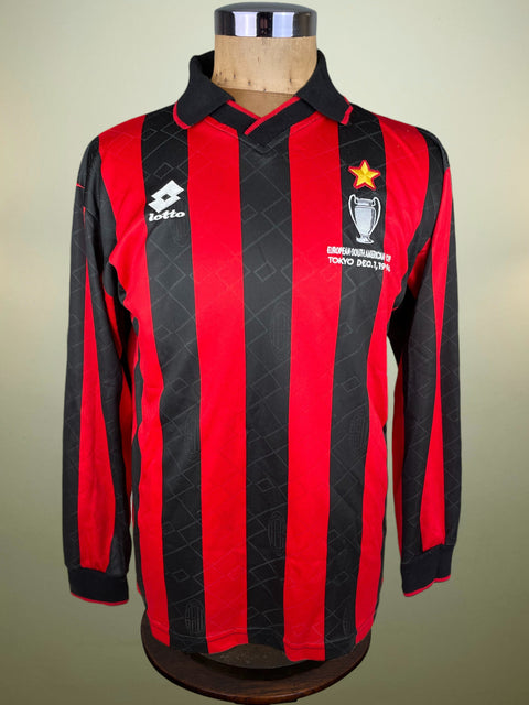 Red and black striped AC Milan Intercontinental Cup Final shirt with a Lotto logo on a mannequin against a beige background