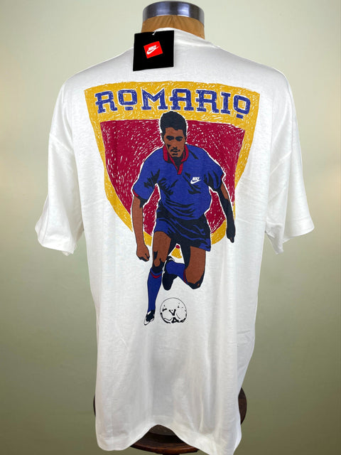 White t-shirt with a graphic of a soccer player and 'Romario' text on a mannequin against a beige background