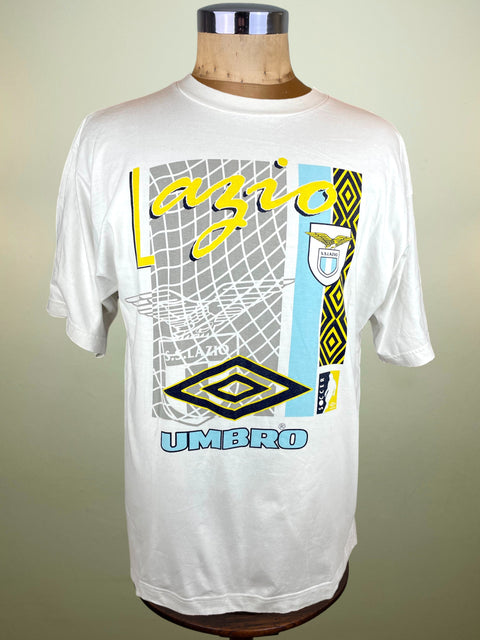 White t-shirt with Lazio and Umbro graphics on a mannequin against a beige background
