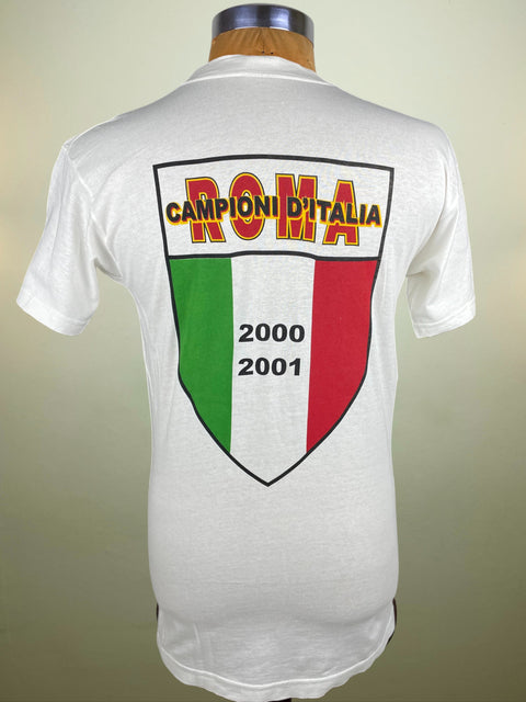 White AS Roma t-shirt with 'Campioni d'Italia' and Italian flag design on a beige background