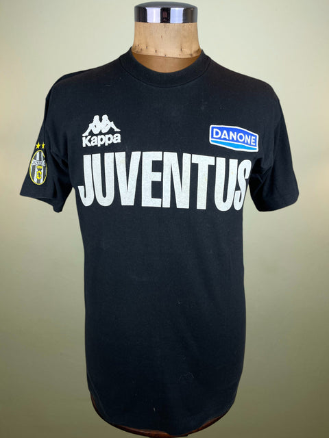 Black Juventus t-shirt with brand logos on a mannequin against a beige background