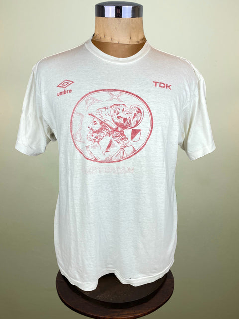 White Ajax t-shirt with red graphic design on a mannequin against a beige background